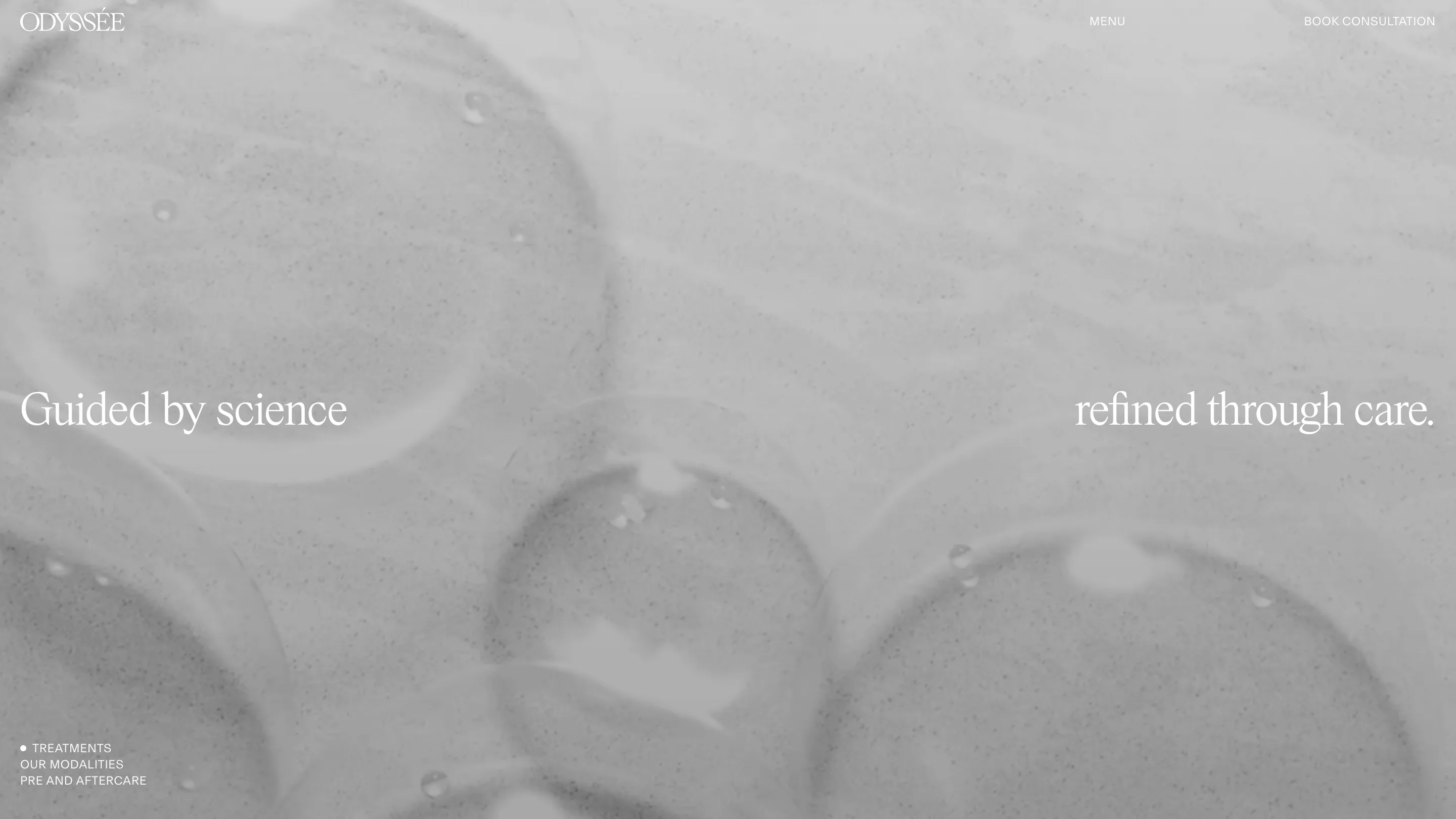 The Odyssée treatments page: "Guided by science" on the left edge and "refined through care." on the right, over grey footage of bubbles in gel