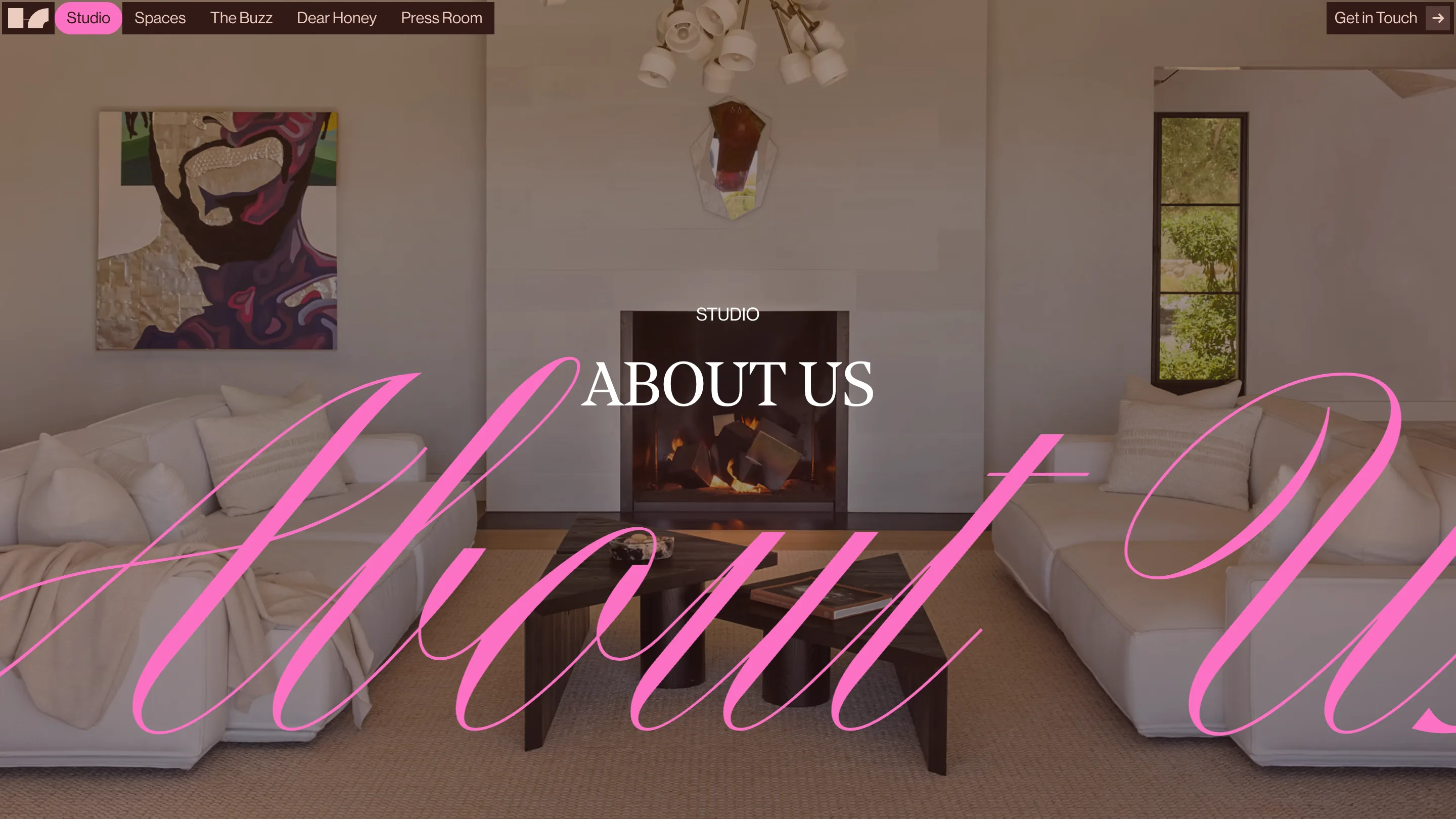 The Studio page with About Us in pink script across a living room with a lit fireplace
