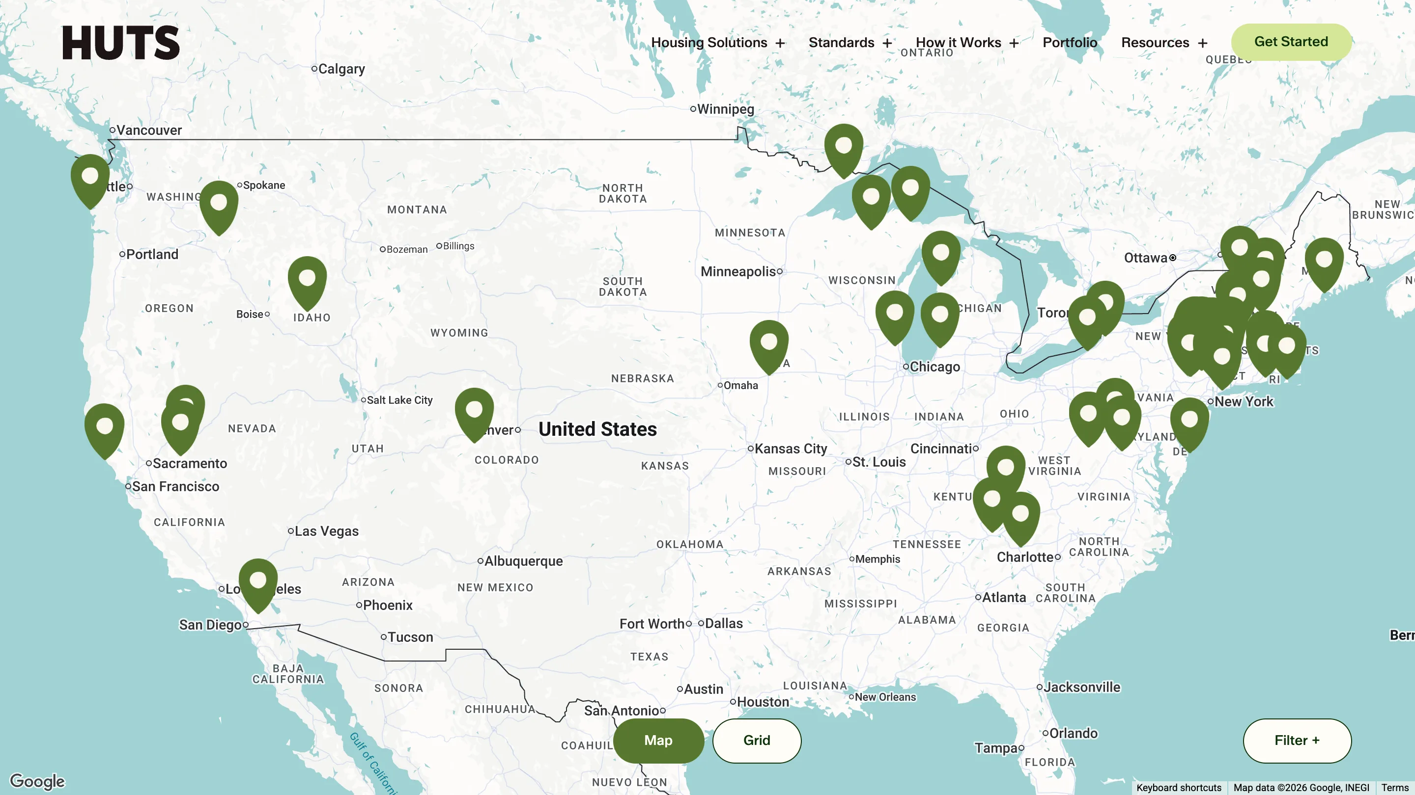 The Huts portfolio page rendered as a map of the US covered in green location pins, with a Map and Grid toggle